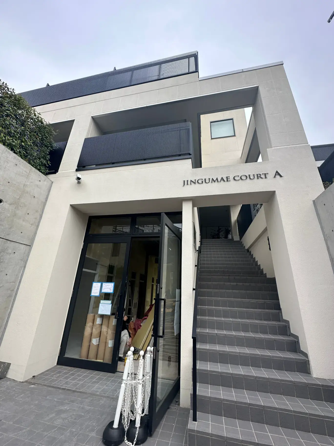 現代的な外観のオフィスビル入口、階段とガラスドアが特徴的な建築デザイン