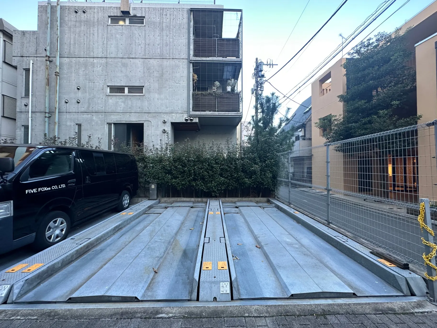 コンクリート打ちっぱなしのデザインが特徴的な建物外観とカーリフト