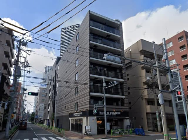 - 現代的なデザインのビル、ストリートビューに映る外観、周囲の電線と交通信号機がある都市の風景