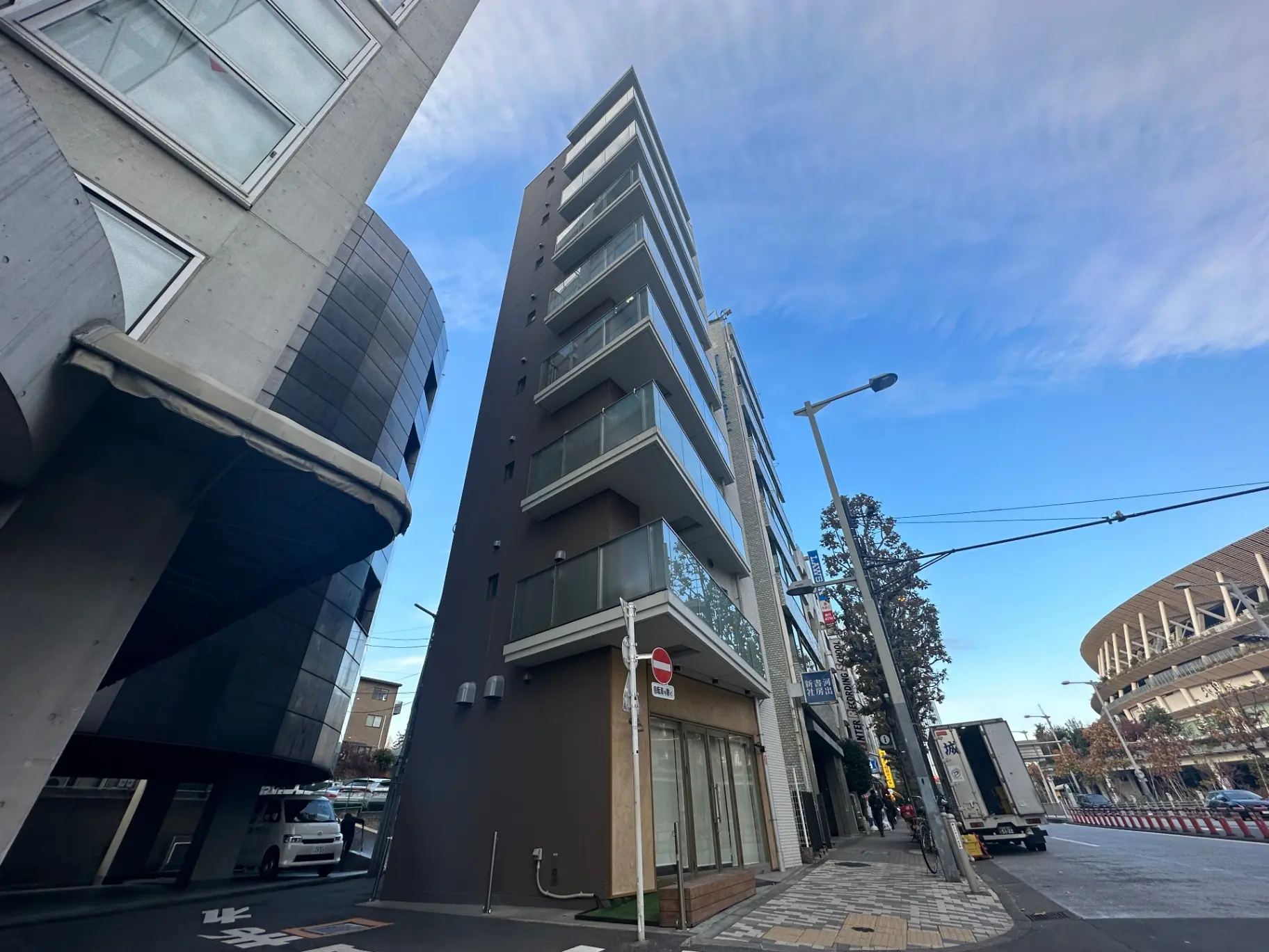 都市の風景、現代的な建物と曲がった壁のある建築物、晴れた空と街路樹