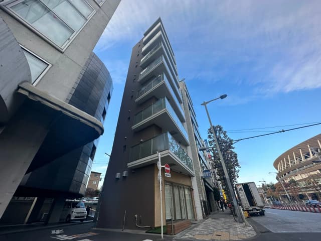都市の風景、現代的な建物と曲がった壁のある建築物、晴れた空と街路樹