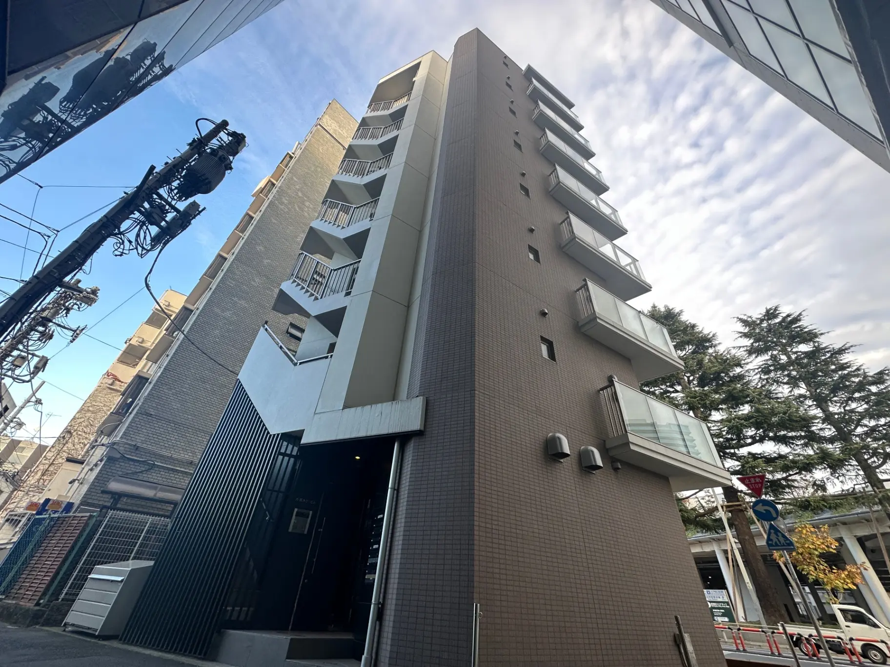 都市のマンションの外観、バルコニー付きの多階建て建物、晴れた日の青空
