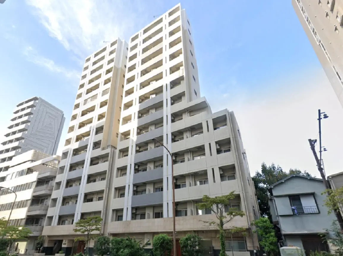 - 現代的なデザインの高層マンション、白い外壁と大きな窓が特徴的な建物の外観、近くに小さな家と緑の植物が見える風景