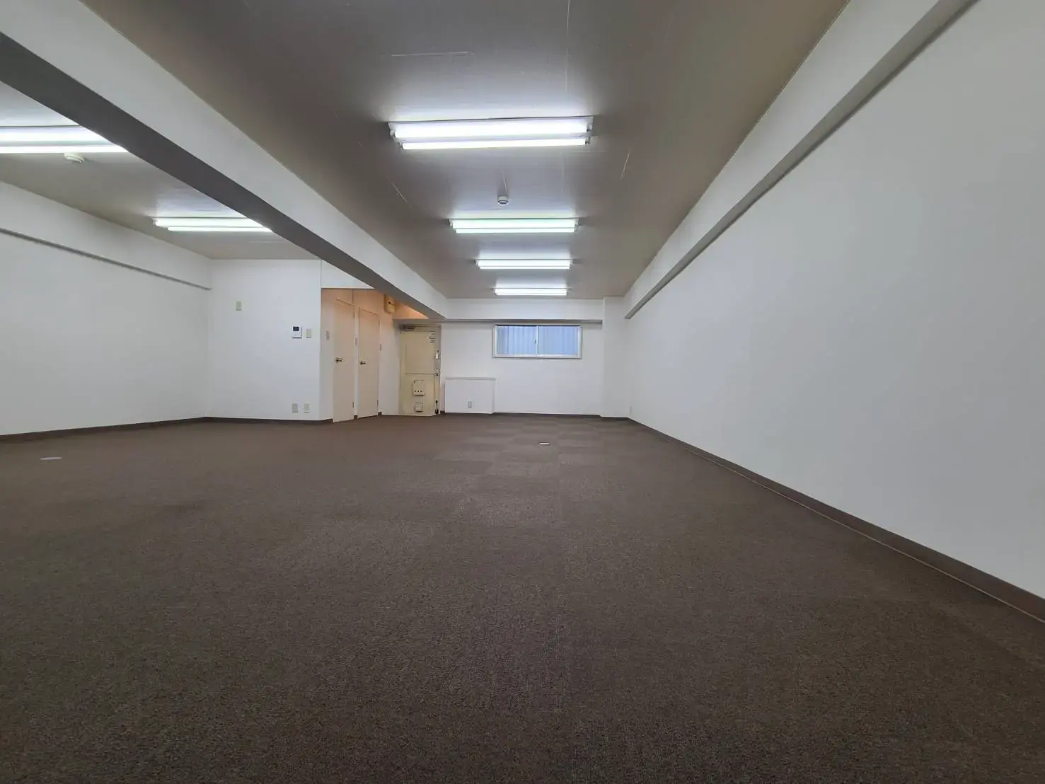 広々としたオープンスペースのあるオフィス、複数の照明設備が整った空間