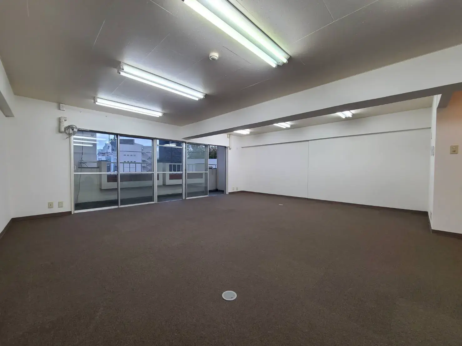 広々とした空間と大きな窓のある明るいオフィス