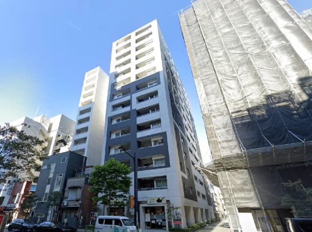 - 近代的なデザインのマンション群、青空の下にそびえる建物とその周辺の様子、工事中の建物も含む街並み