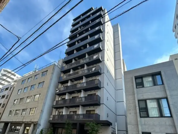 - 現代的なデザインの高層マンション、バルコニー付きの外観と隣接する建物が並ぶ都市風景