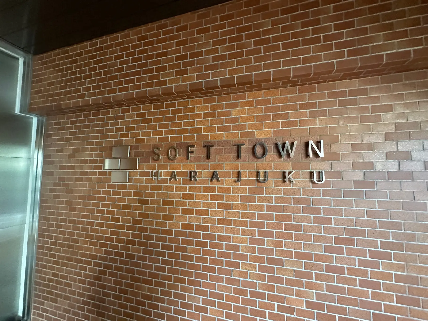 レンガ壁に設置された「SOFT TOWN HARAJUKU」という立体文字の看板