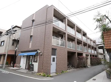 - モダンな外観の住宅ビル、バルコニー付き、街角の商店が近くにある静かな住宅街の風景