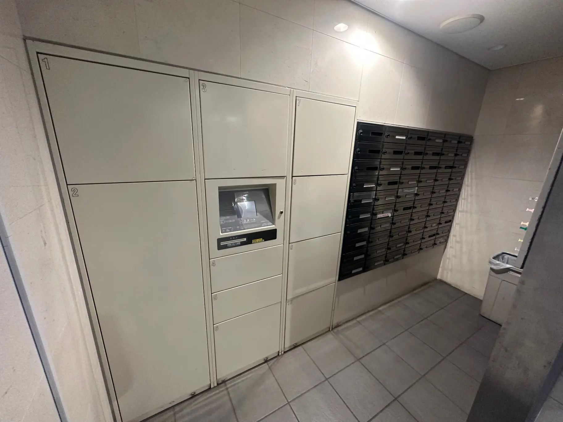 集合住宅の室内に設置された宅配ボックスと郵便受け、セキュリティシステム付きのモダンなエントランスエリア