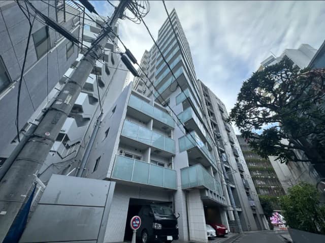 現代的なデザインのマンションが立ち並ぶ都市の風景、電柱と配電線が見えるクリアな日中の写真