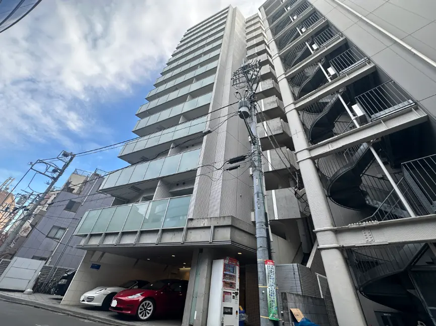 現代的なマンションの外観、多層階建て、青空と雲の背景