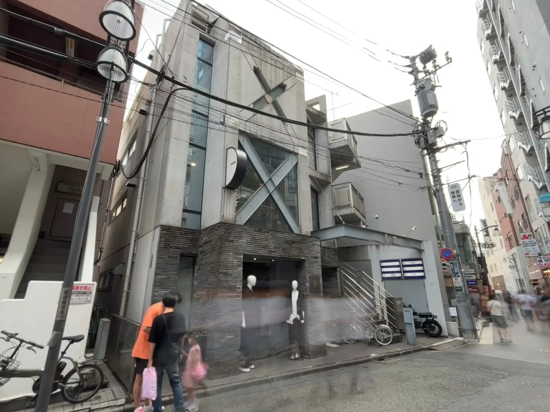 - モダンな外観の建物、コンクリートとガラスを使用し、ショーウィンドウにマネキンがディスプレイされている街角の風景