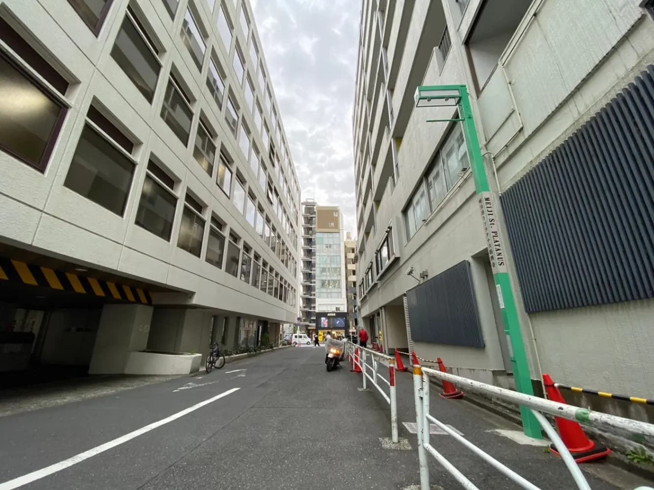 都市の道路とオフィスビル、車と自転車がある風景