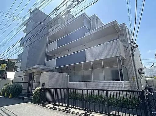 - モダンな外観のアパートメントビル、グレーのタイル張りと大きな窓が特徴、電線が画面上部に見える景観