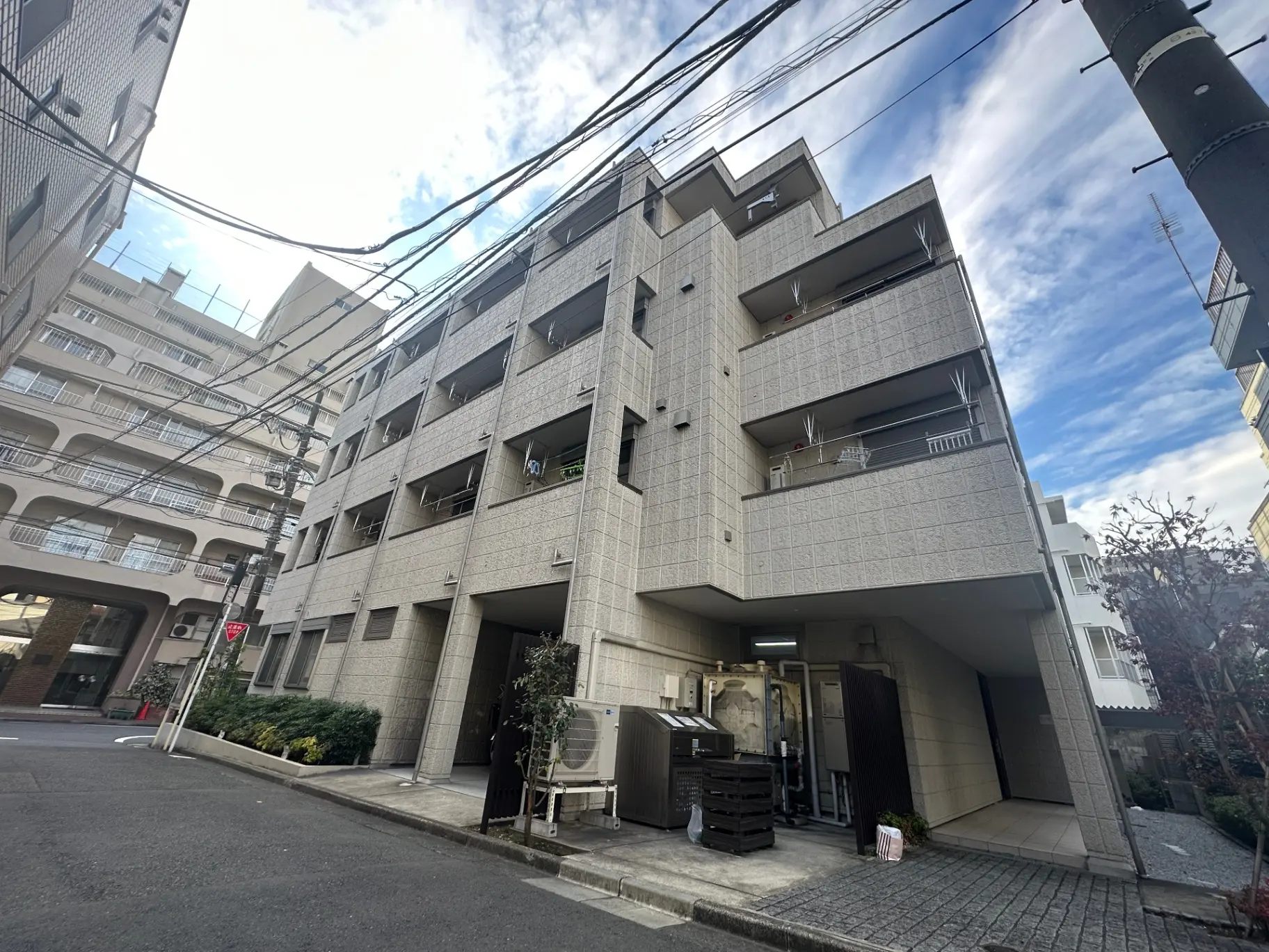 市街地にあるモダンな外観のマンションビル、晴れた日の住宅街の風景