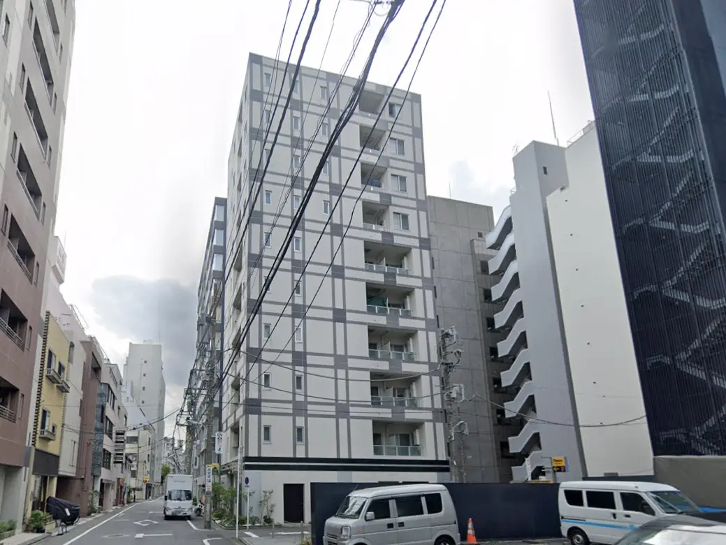 - 近代的なデザインのマンションが並ぶ都市の風景、電線が走る街路の様子
