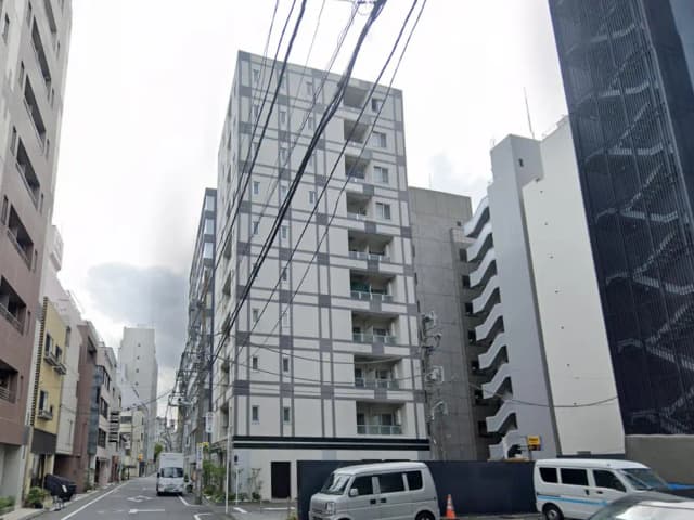 - 近代的なデザインのマンションが並ぶ都市の風景、電線が走る街路の様子