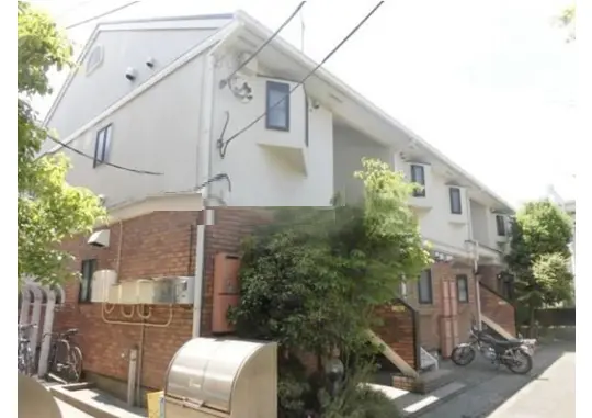 - 自然光が差し込む閑静な住宅街にある二階建てのアパート、レンガ調の外壁と緑豊かな植栽が特徴