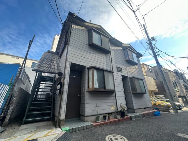 都市の住宅街にある2階建ての現代的な家、外階段付きの外観デザイン