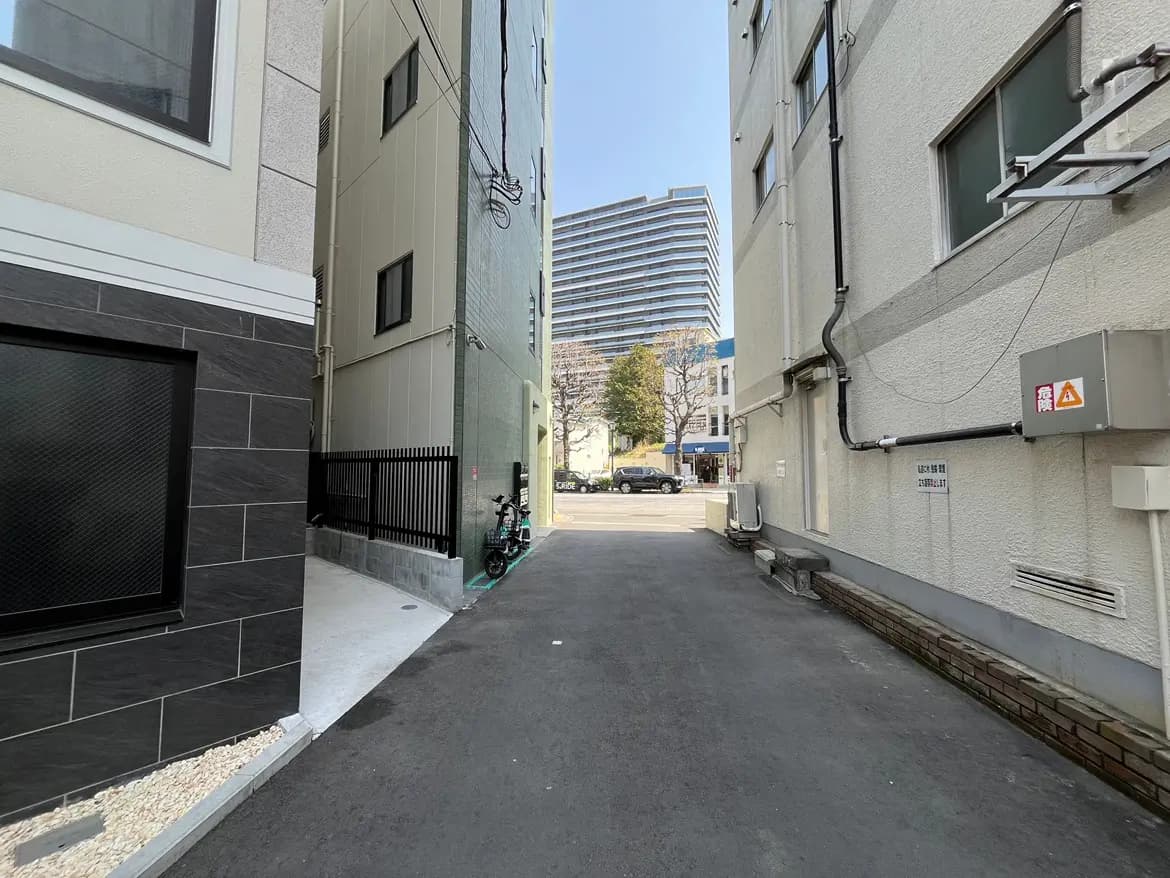 都市の狭い路地、ビルとアスファルトの通り、晴れた日の都会の風景