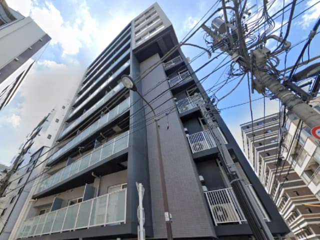 - 都市部に立つ高層マンション、バルコニー付きのモダンなデザインと電線が交差する街景