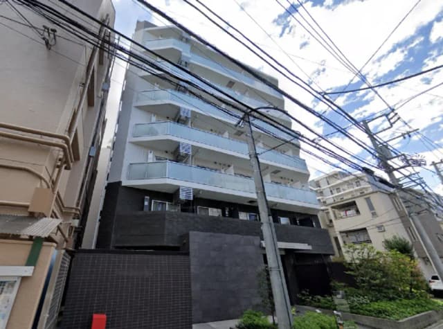 - 近代的な外観のマンション、ベランダ付きのバルコニーがある5階建ての建物、周囲に電柱と電線が見える街並み