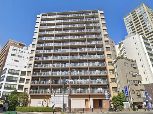 - 都市型の現代的なマンション、バルコニー付きの広い外観と青空に映えるビル群の景観