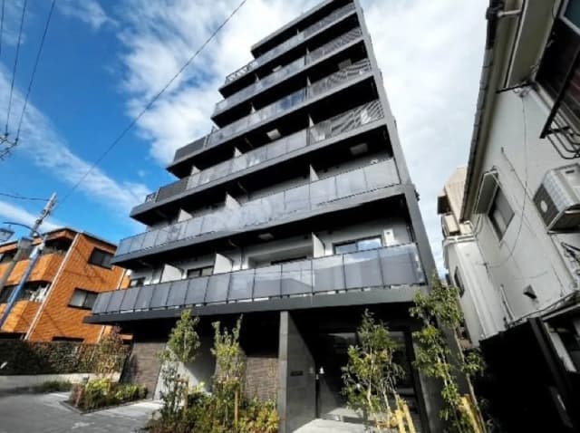 - モダンなデザインの7階建てマンション、透明なバルコニーと上部に広がる青空の背景、静かな住宅街に位置する景観