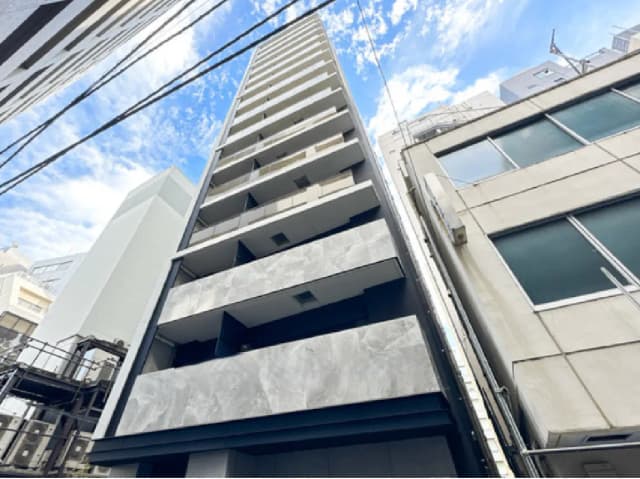 - 高層マンションの外観、青空を背景にした現代的なデザインのバルコニーが並ぶ構造