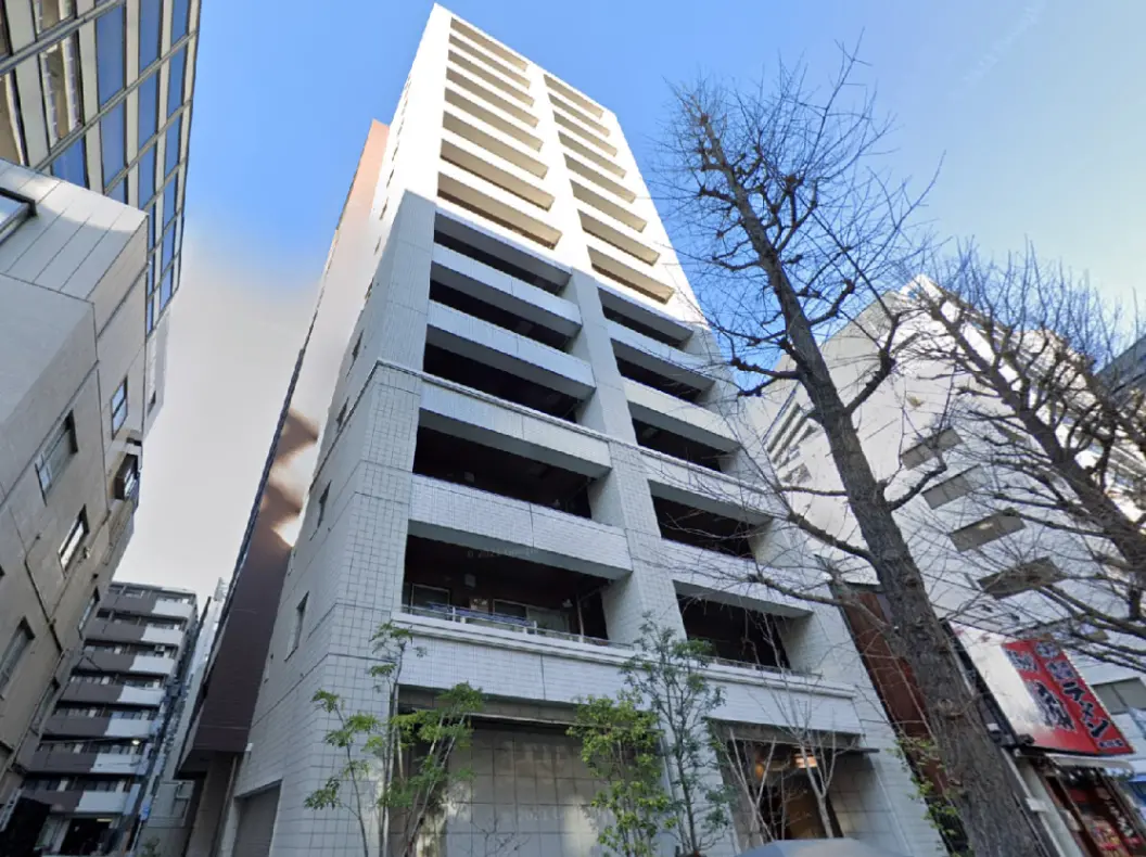 - 都市部に立つモダンなアパートメントビル、白いタイル張りの外観とバルコニー、周囲の建物との調和を見せるデザイン