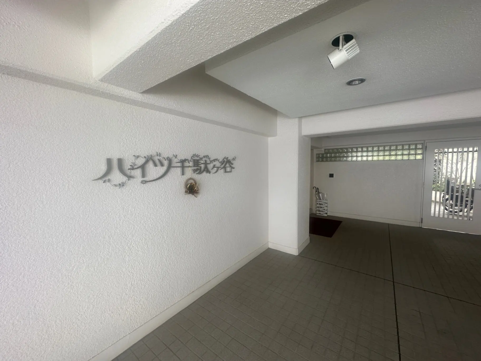 明るく広々としたエントランスホール、壁に「エリアイサービス」と書かれたサイン、近代的な照明と通風のためのガラスブロック窓