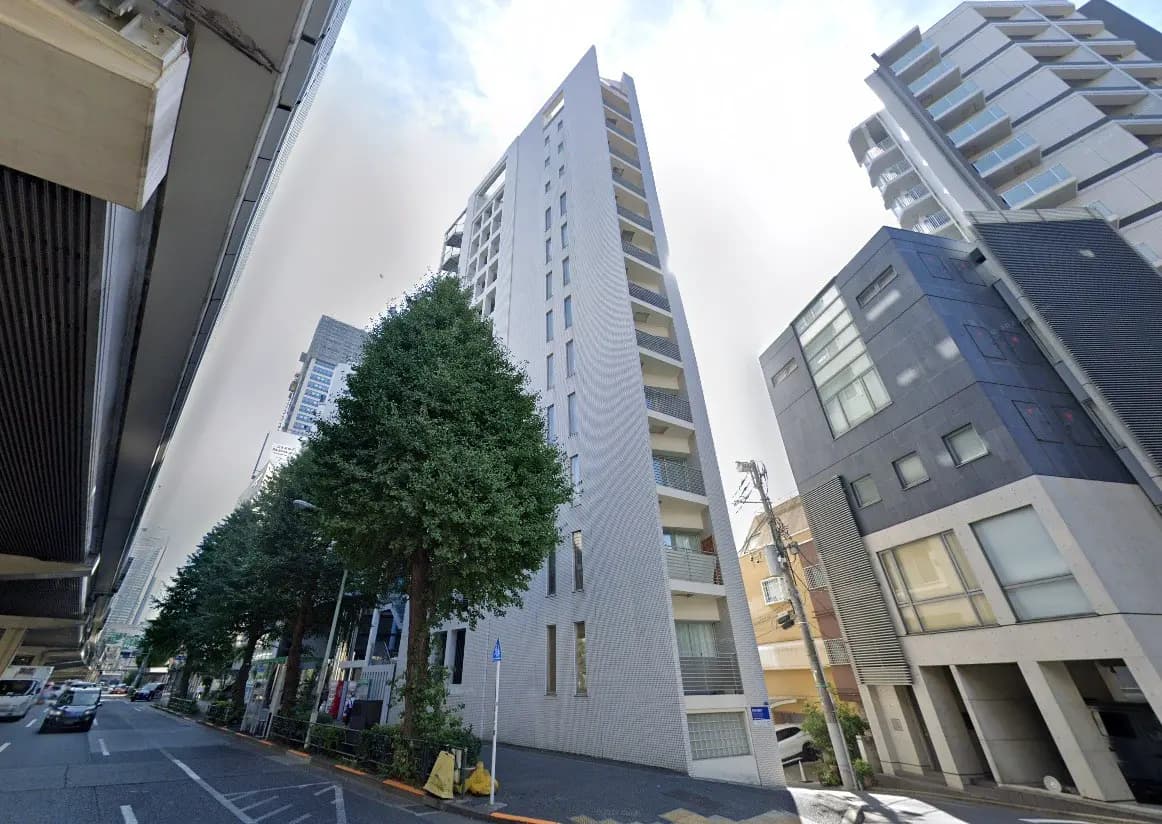 - 高層ビルが立ち並ぶ都市の通り、緑の木々とモダンな建物のコントラストが印象的な風景
