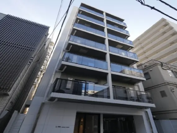 - モダンな外観の5階建てマンション、バルコニーとガラス手すりのあるデザイン、周囲の建物とコントラストを成す都市景観
