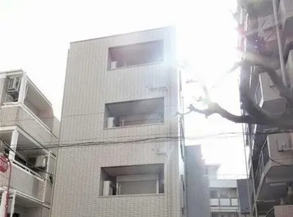 - 明るい光が差し込む外観の建物、シンプルなデザインの3階建て住宅と周囲の街並み