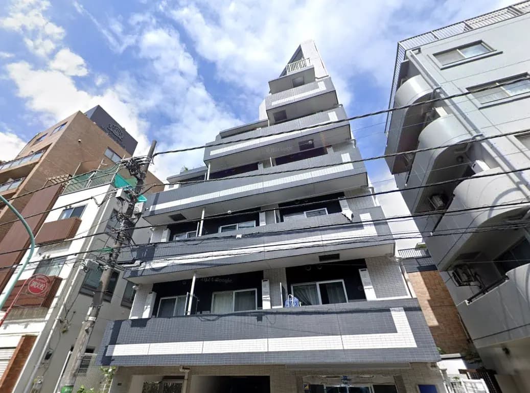 日本の都市部にある現代的なマンションの外観、晴れた日の青空と街並み