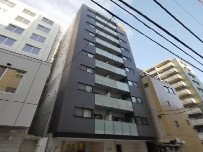 - 現代的なデザインのマンション外観、バルコニー付きのスタイリッシュな7階建ての建物、周囲には他の住宅が並ぶ住宅街の風景
