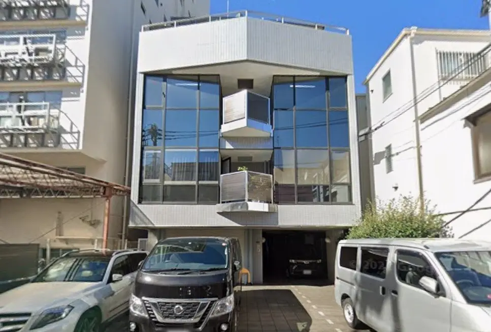 モダンな外観の都市型マンション、大きな窓とバルコニーが特徴的、駐車場付きの住宅街