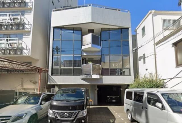 モダンな外観の都市型マンション、大きな窓とバルコニーが特徴的、駐車場付きの住宅街
