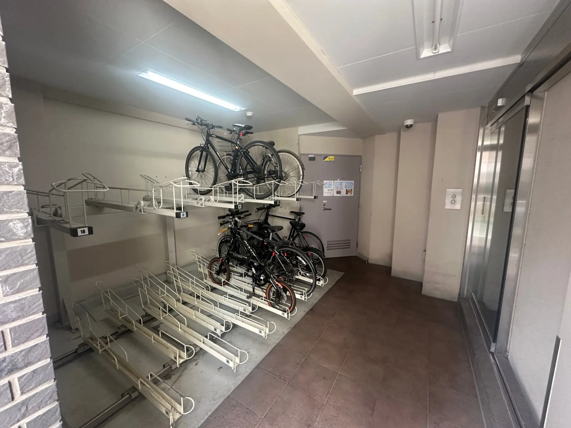 マンションの自転車置き場、壁掛け式の自転車ラックとクリーンな内装