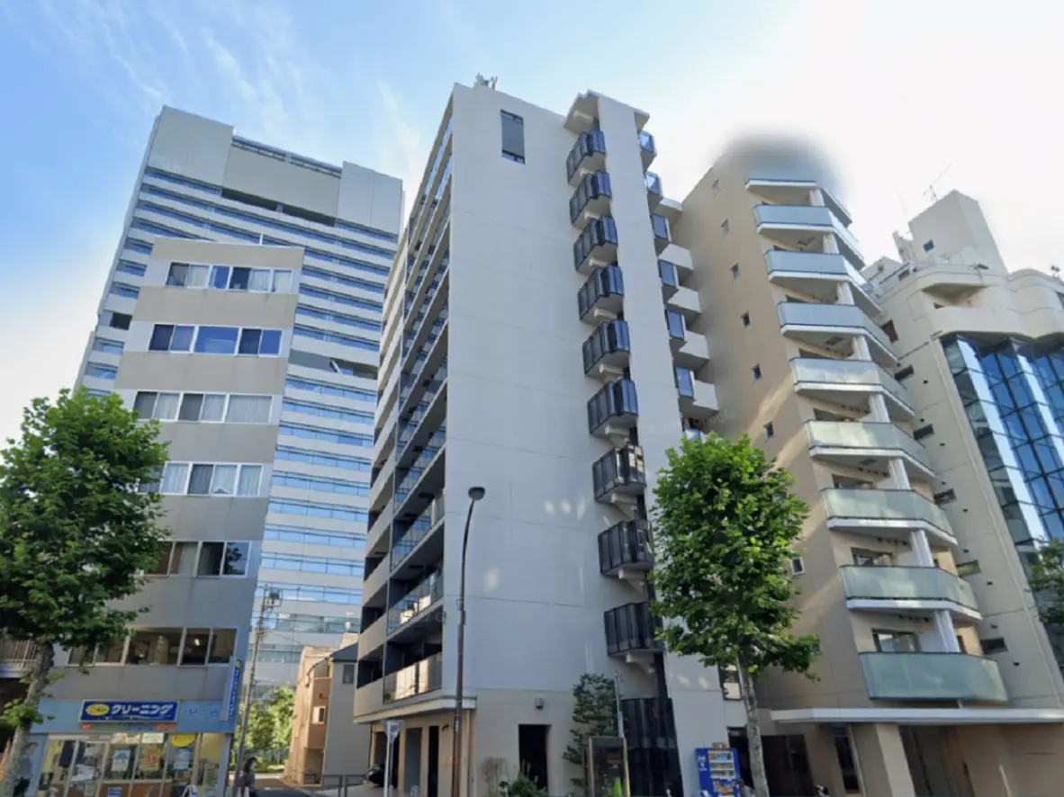 - 都市の景観に立つ現代的なマンション、ガラスバルコニーと街路樹があるエリアの建物群