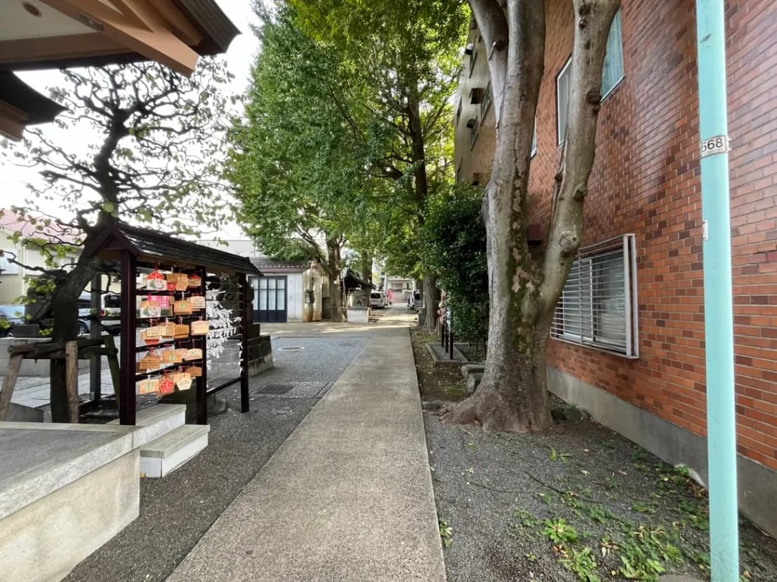 日本の町の通り角にある神社とレンガ造りの建物、木々とともに落ち着いた雰囲気の景観