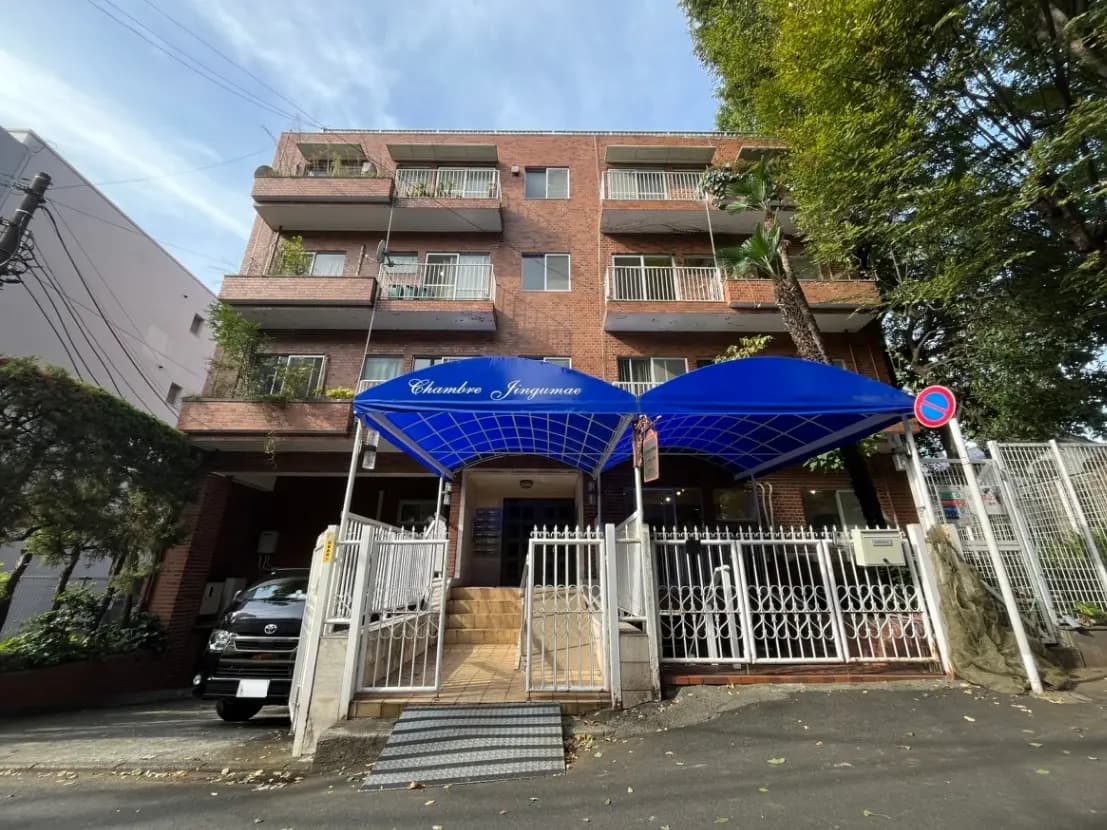 青い日よけが目を引くレンガ造りのアパートの入り口、都市の住宅風景