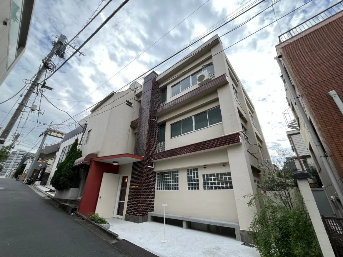 都市の住宅街にある現代的な外観のアパートメントビルディング、晴れた日の静かな通り