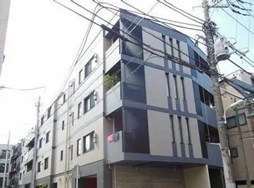 - モダンな外観の集合住宅、グレーとホワイトのファサード、周囲に電線が目立つ立地