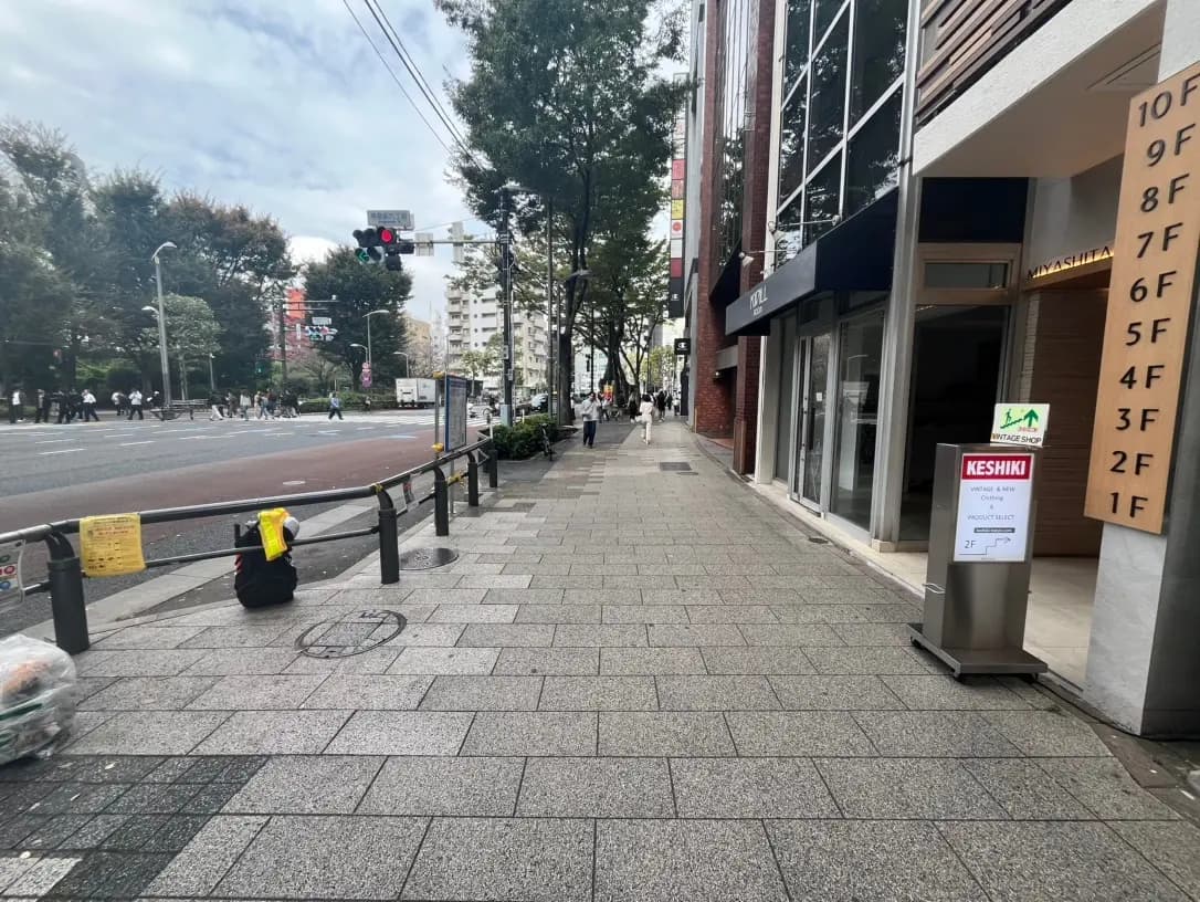 都市の歩道とビル、日中の明るい街並みと信号のある交差点