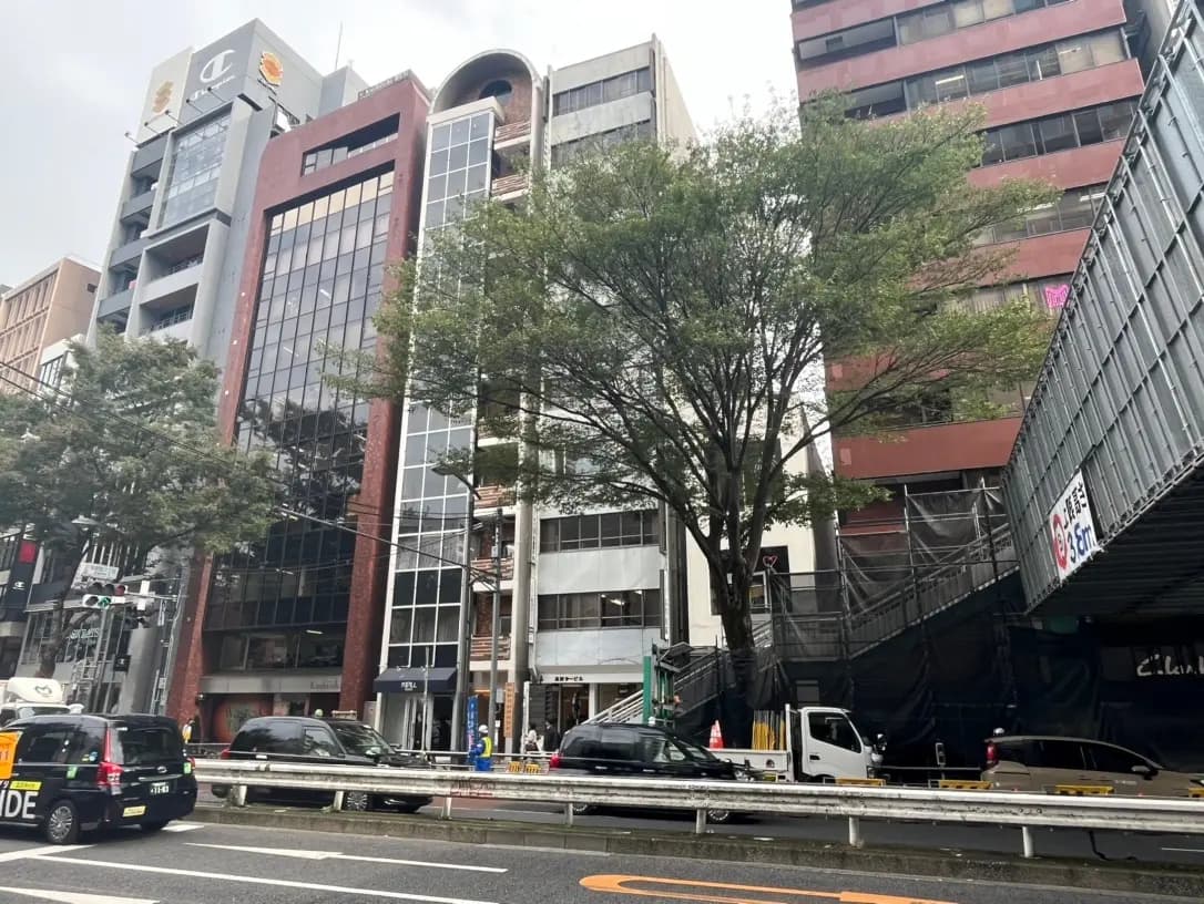 現代的な建築スタイルのビルと緑豊かな街路樹、雲ひとつない晴れた日の都市風景