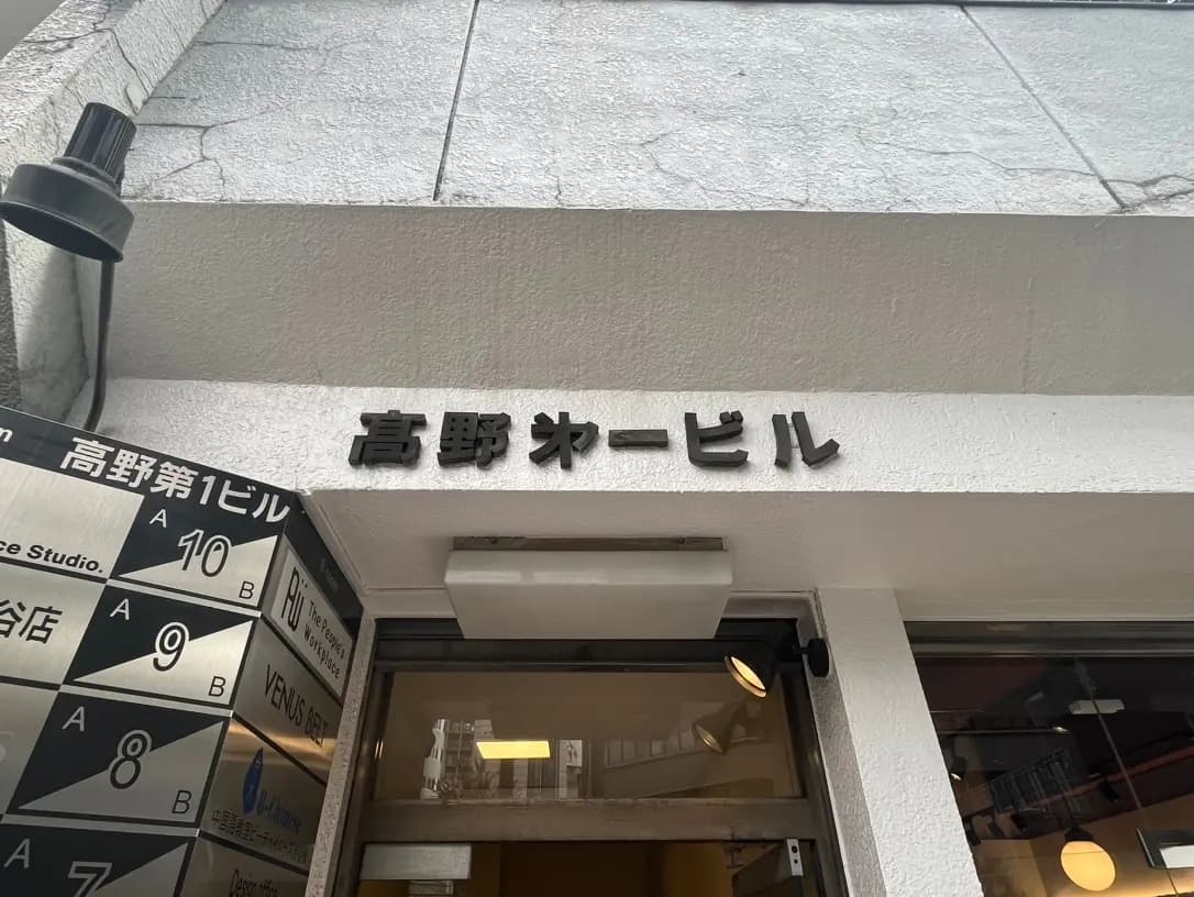 建物のエントランスに掲げられた「吉野家」の看板と案内板が見える写真