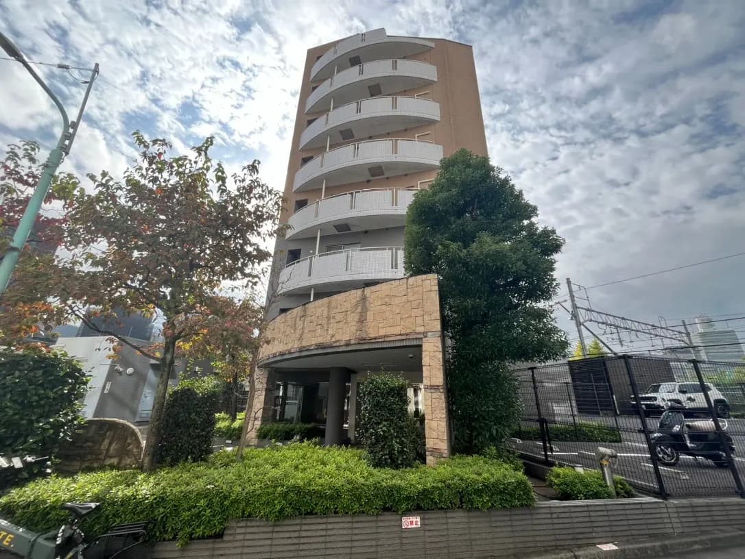 現代的なデザインのマンション外観、緑豊かな庭園、晴れた日の雲の流れ
