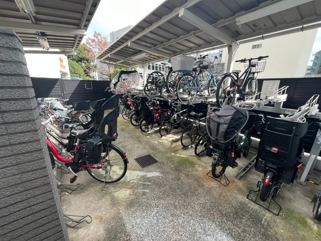 屋根付きの自転車駐輪場で整理された多くの自転車、都会的なビルの背景